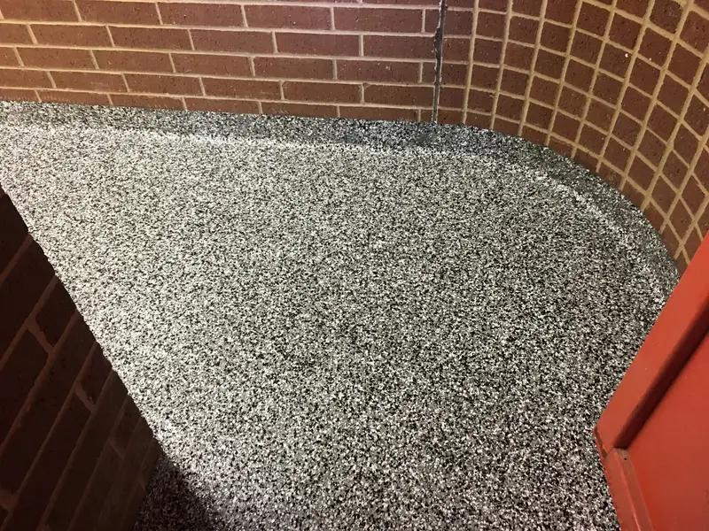 Flake epoxy floor with a cove base against brick walls