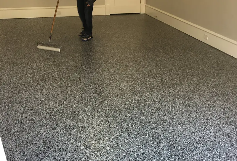 Flake epoxy being applied to a garage floor