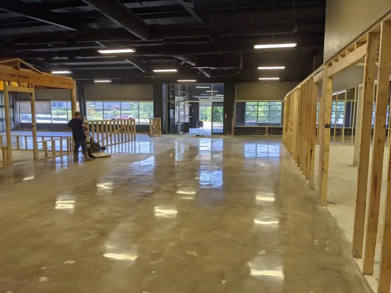 Polished concrete in a commercial build-out with wood framing in progress