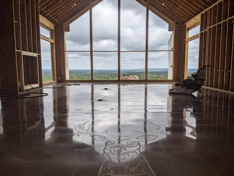 Polished concrete with an etched deer design in front of floor-to-ceiling windows