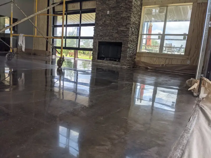 Polished concrete in a new home with a stone fireplace