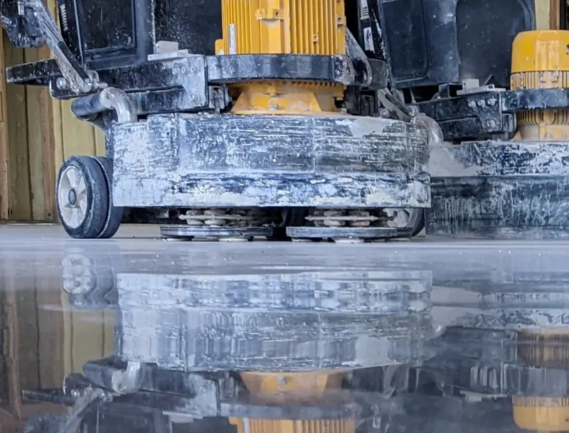 Concrete grinder reflected in a freshly polished floor