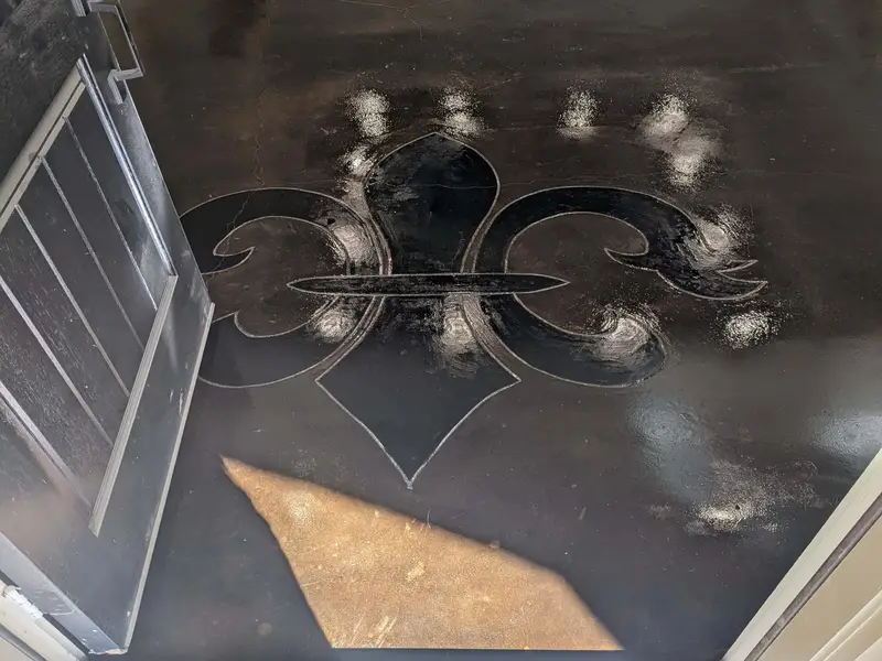 Black stained concrete with a fleur-de-lis design