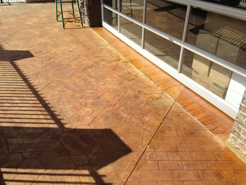 Stamped and stained concrete patio by a sunroom