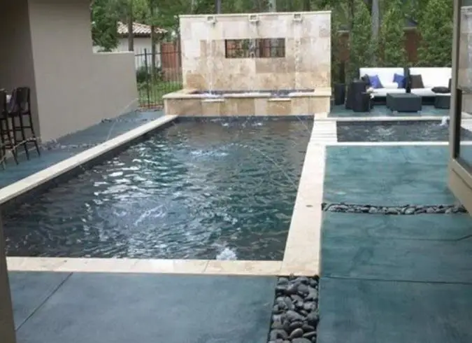 Teal stained concrete around a swimming pool