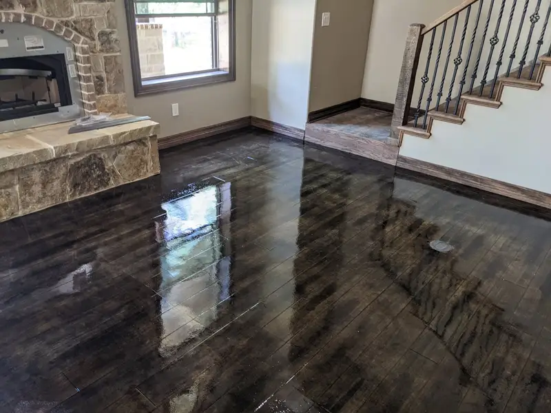 Wood-look concrete floor in a living room with a stone fireplace
